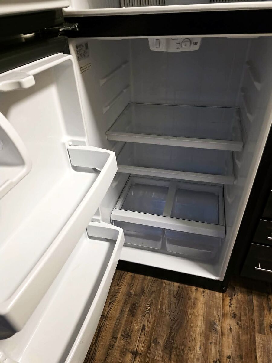 Same refrigerator interior after cleaning, shelves clear and sanitized